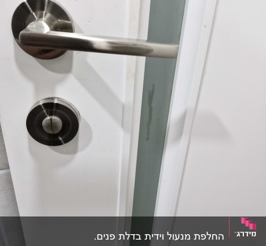 תקריב של דלת פנים לבנה מעוצבת עם פס זכוכית וידית ניקל